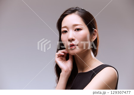 黒いドレスでポージングする女性モデルのスタジオポートレート 黒いドレスでポージングする女性モデルのスタジオポートレート 129307477