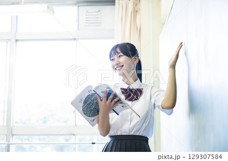 黒板の前で発表する女子高生 黒板の前で発表する女子高生 129307584
