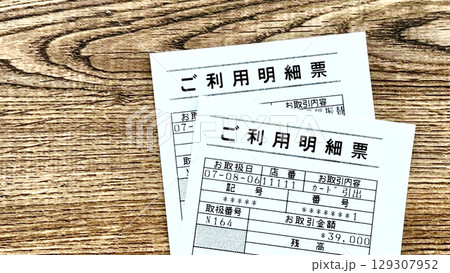 銀行ATMのご利用明細票2枚_茶色板背景俯瞰 銀行ATMのご利用明細票2枚_茶色板背景俯瞰 129307952