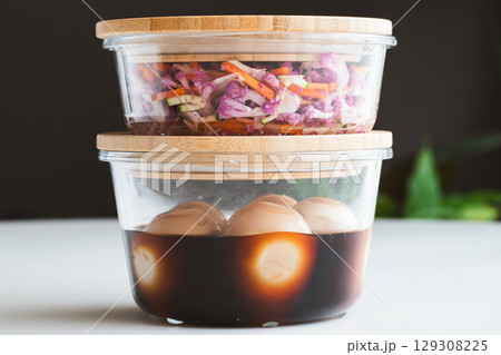 ガラスの保存容器に入った、作り置きの家庭料理 129308225