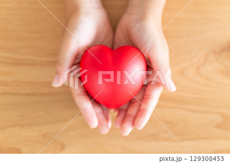 ハートを持つ小学生の男の子の手 129308453