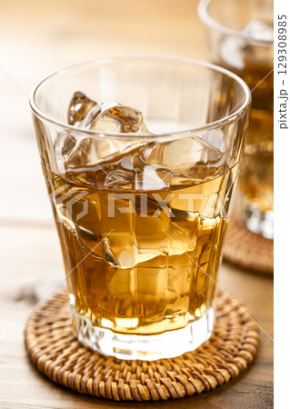 明るい木目テーブルに並べた氷入りの麦茶グラス 129308985