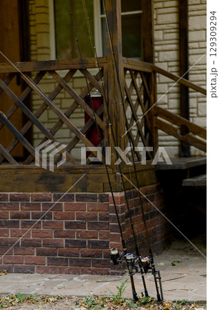 Fishing Pole lay on a terrace waiting for some fish in a sunny day. Fishing Pole lay on a terrace waiting for some fish in a sunny day. 129309294