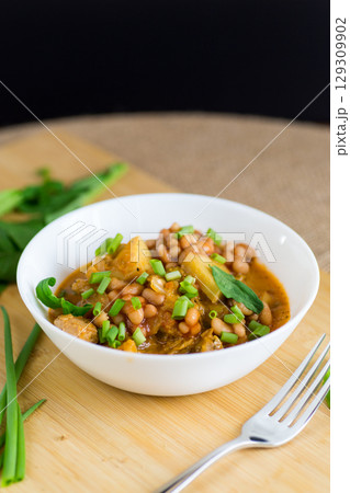 Vegetable stew with meat and potatoes in a white bowl on the table 129309902