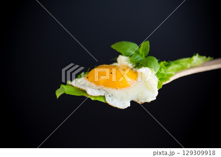 Homemade breakfast with fried egg and fresh lettuce leaves 129309918