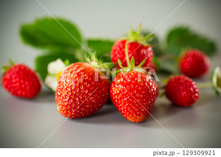 Bright ripe strawberries on a neutral gray surface 129309921