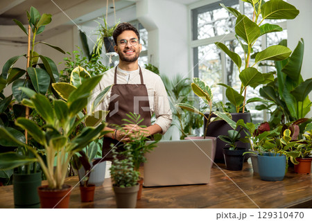 Male shop assistant in the flower shop feeling confident Male shop assistant in the flower shop feeling confident 129310470