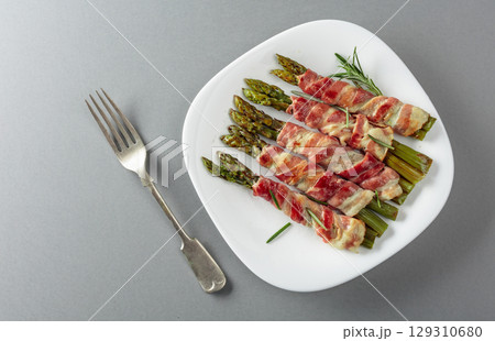 Grilled green asparagus wrapped in bacon. Grilled green asparagus wrapped in bacon. 129310680