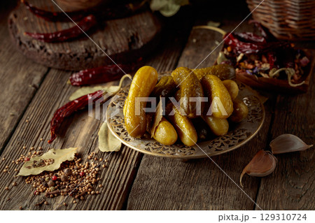 Pickled cucumbers with ingredients on an old wooden table. Pickled cucumbers with ingredients on an old wooden table. 129310724