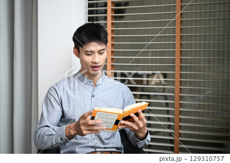 Confident male entrepreneur reading and reflecting in a calm office environment Confident male entrepreneur reading and reflecting in a calm office environment 129310757