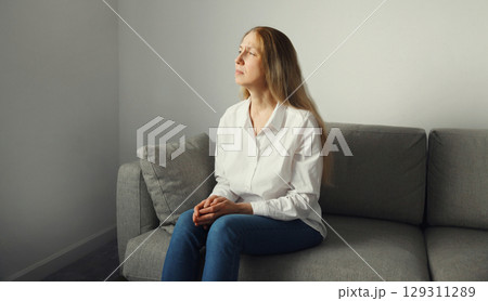 Pensive woman thinks looks out the window, thoughtful girl suffering from depression at home 129311289
