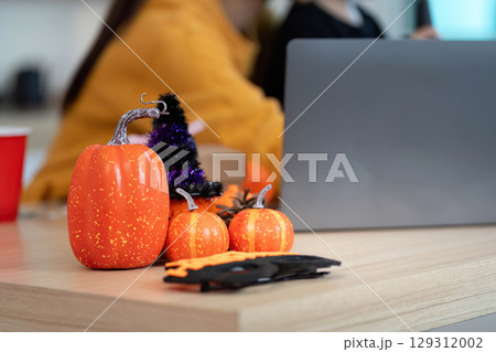 Halloween Decor. Festive orange pumpkins and decorations on a wooden table. 129312002