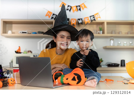 Halloween Moments. Mother and son sharing smiles in festive witch hats. 129312014