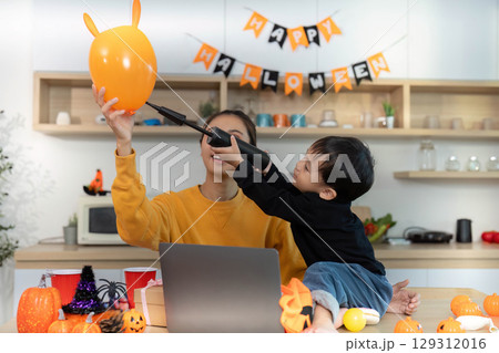 Halloween Celebration. Mother and son playing with balloons and festive decorations. Halloween Celebration. Mother and son playing with balloons and festive decorations. 129312016
