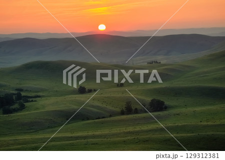 Sun rises over a picturesque mountain valley Sun rises over a picturesque mountain valley 129312381