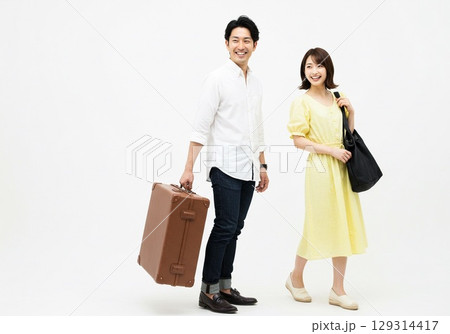 これから旅行に出かける楽しそうな若い日本人のカップル（白背景・切り抜き用） 129314417