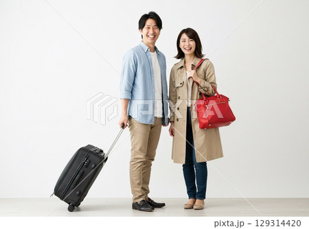これから旅行に出かける楽しそうな若い日本人のカップル（白背景・切り抜き用） 129314420