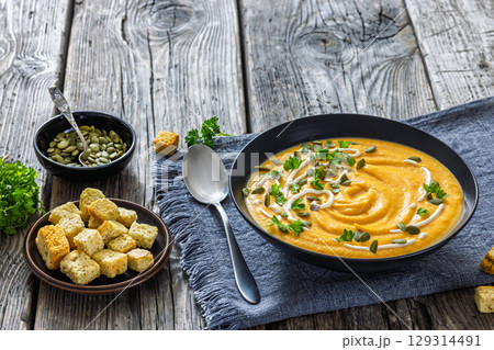 roasted pumpkin puree soup in a black bowl roasted pumpkin puree soup in a black bowl 129314491