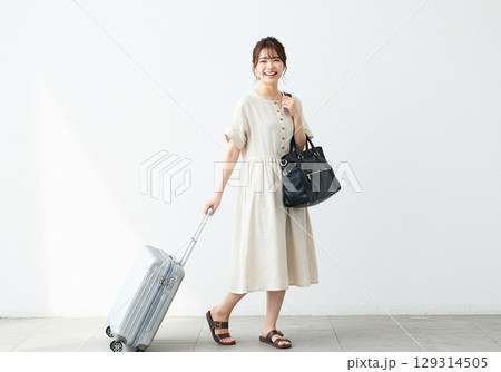 これから旅行に出かける楽しそうな日本人の若い女性（白背景・切り抜き用） 129314505