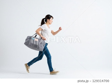 乗り物に乗り遅れそうになり急いで走る日本人の女性（白背景・切り抜き用） 129314700