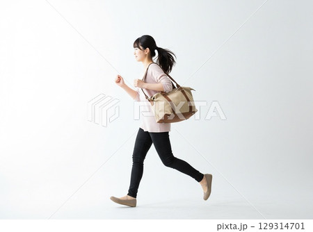乗り物に乗り遅れそうになり急いで走る日本人の女性（白背景・切り抜き用） 129314701