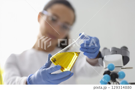 Lab technician conducts qualitative analysis of chemical compound in a modern laboratory setting during daylight hours Lab technician conducts qualitative analysis of chemical compound in a modern laboratory setting during daylight hours 129314880