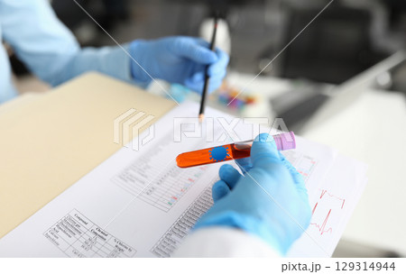 Laboratory technicians conducting tests in a modern lab setting with colorful samples and thorough documentation Laboratory technicians conducting tests in a modern lab setting with colorful samples and thorough documentation 129314944