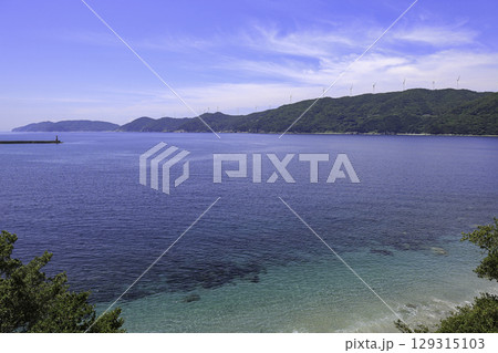 愛媛県伊方町の青い海と佐田岬半島に並ぶ風車の風景 129315103