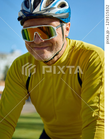 Close-up of older man smiling with bike helmet and sunglasses Close-up of older man smiling with bike helmet and sunglasses 129315832