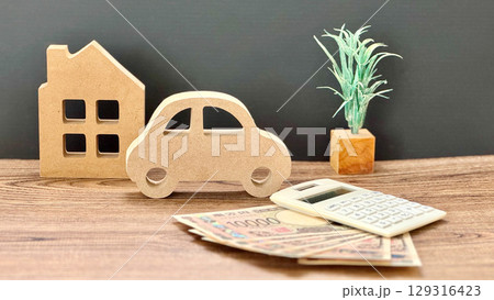 車と家の小物とお金と計算機_黒背景 129316423