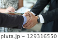 Business deals flourish with firm handshakes in a modern office setting during a bright afternoon 129316550
