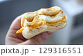 Delicious breakfast biscuit filled with creamy egg and melted cheese enjoyed in a cozy kitchen setting 129316551