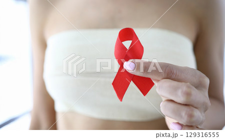 Supporting awareness through a red ribbon during a health initiative in the community on a sunny day Supporting awareness through a red ribbon during a health initiative in the community on a sunny day 129316555