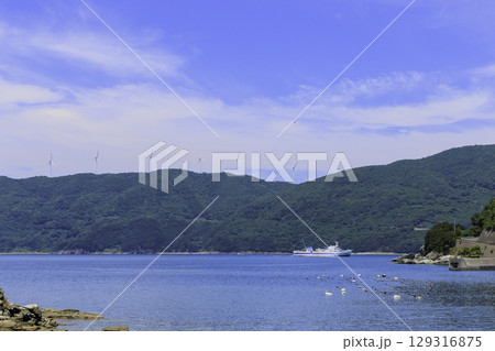 佐田岬半島の風車と伊方町の海に浮かぶフェリーの夏風景 佐田岬半島の風車と伊方町の海に浮かぶフェリーの夏風景 129316875
