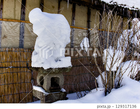雪の積もった灯篭が埋もれている南会津大内宿の風景 129317136