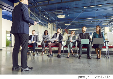 Male business coach speaker in suit giving presentation, speaker presenter consulting training  129317512