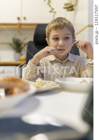 Child eating lunch at home and playing with fork Child eating lunch at home and playing with fork 129317997