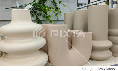 Collection of modern minimalist ceramic vases with organic shapes and matte finish on store shelf Collection of modern minimalist ceramic vases with organic shapes and matte finish on store shelf 129318699