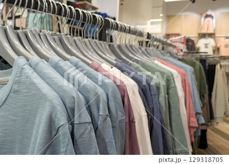 Long shot of clothing rack in store, displaying variety of different colored cotton t-shirts and tops Long shot of clothing rack in store, displaying variety of different colored cotton t-shirts and tops 129318705