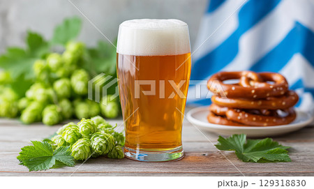 Refreshing beer served with pretzels and hops on a rustic wooden table, perfect for a casual gathering or Oktoberfest celebration 129318830