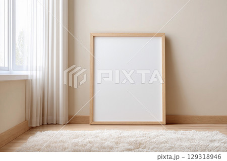 Empty picture frame for mockup placed on wooden floor next to bright window with curtains in modern room setting during daylight hours 129318946