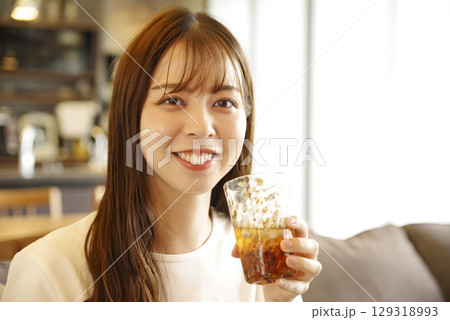 笑顔でアイスティーを飲む女性 笑顔でアイスティーを飲む女性 129318993
