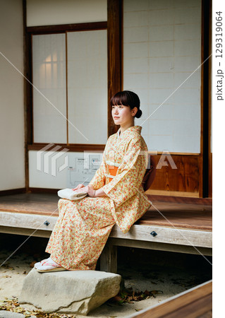 縁側で静かに佇む着物姿の女性 129319064