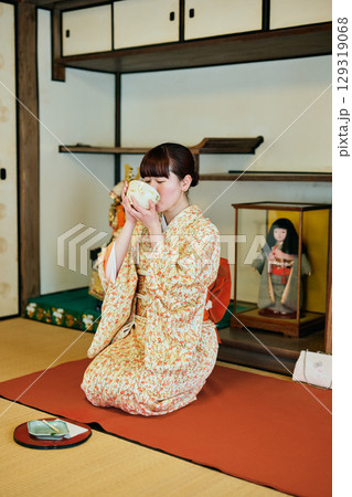 和室で茶道体験を楽しむ着物姿の女性 129319068
