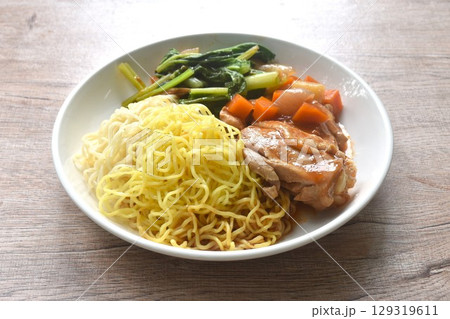 Chinese egg yellow noodles and cabbage with baking chicken gravy sauce on plate 129319611