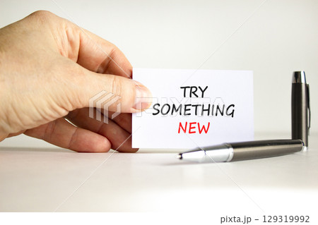 Try something new symbol. Concept words Try something new on beautiful note. Beautiful white background. Businessman hand, pen. Business motivational lifestyle try something new concept. Copy space. 129319992