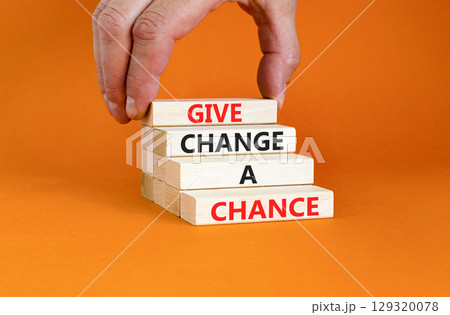 Give change a chance symbol. Concept words phrase Give change a chance on beautiful wooden blocks. Beautiful orange paper background Businessman's hand Business Give change a chance concept Copy space 129320078