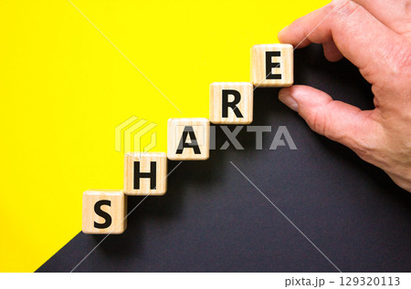 Share symbol. Concept word Share on beautiful wooden blocks. Beautiful yellow and black background. Businessman hand. Business lifestyle share concept. Copy space. 129320113