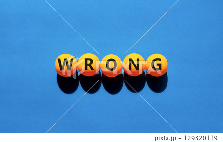 Wrong symbol. Concept word Wrong on beautiful yellow tennis ping pong balls. Beautiful wooden table wooden background. Business lifestyle wrong concept. Copy space. Wrong symbol. Concept word Wrong on beautiful yellow tennis ping pong balls. Beautiful wooden table wooden background. Business lifestyle wrong concept. Copy space. 129320119
