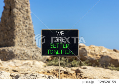 We are better together symbol. Concept words phrase We are better together on beautiful black blackboard. Beautiful stone blue sky background. Business We are better together concept. Copy space. 129320159
